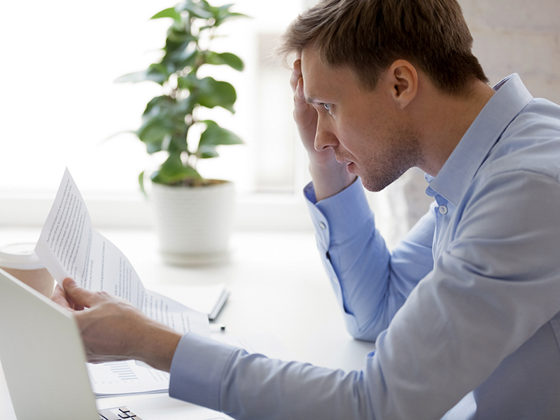 Man reading notification from bank about unpaid debt